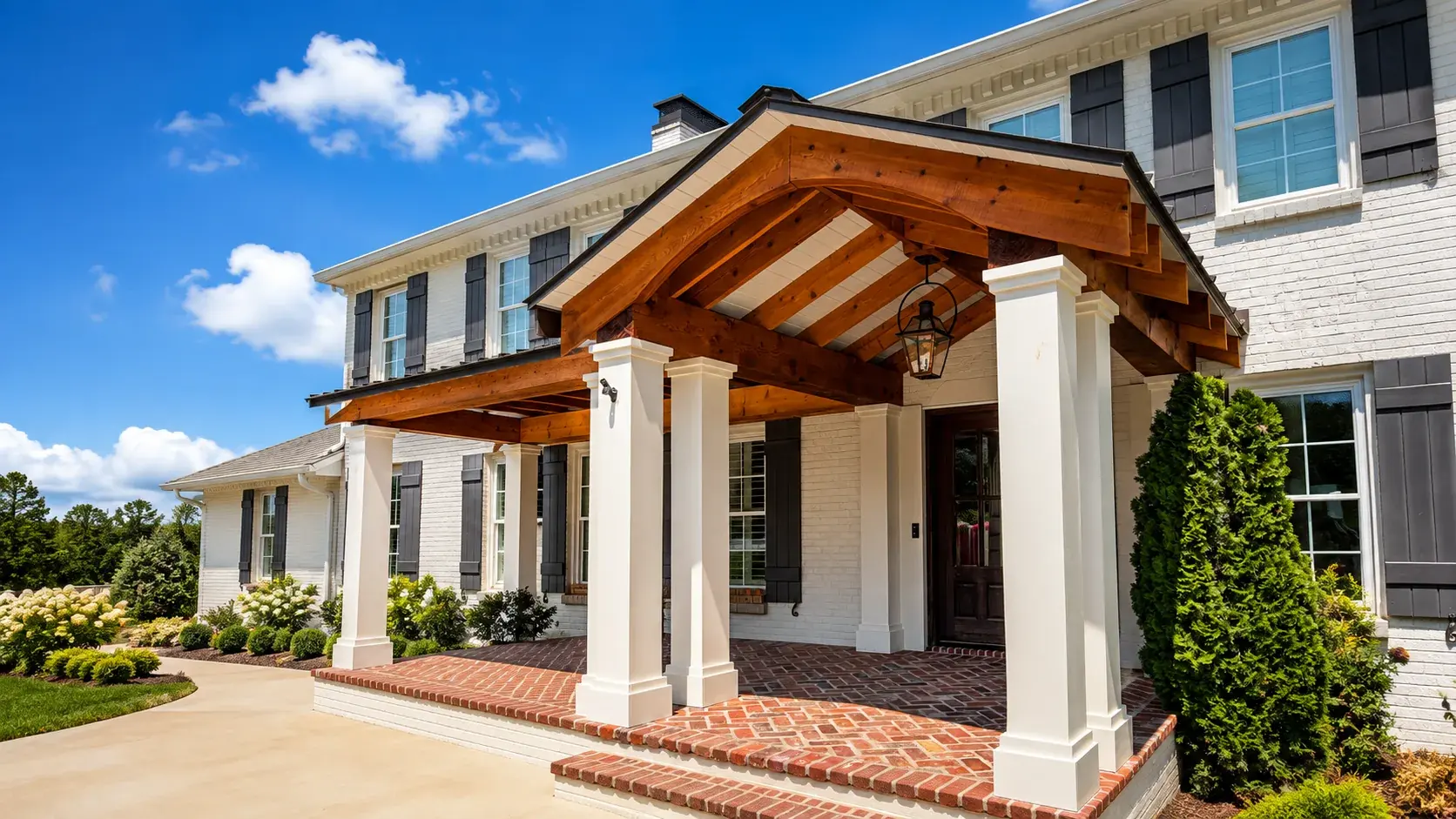 White painted brick home with a stained cedar portico and brick steps after exterior painting in Nashville TN